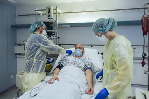 Ärzte, die sich um einen Patienten in der Notaufnahme eines Krankenhauses kümmern, messen die Temperatur - MFF05305