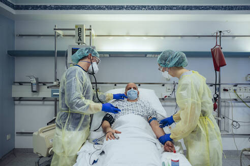 Ärzte, die einen Patienten in der Notaufnahme eines Krankenhauses versorgen, nehmen eine Blutprobe - MFF05306