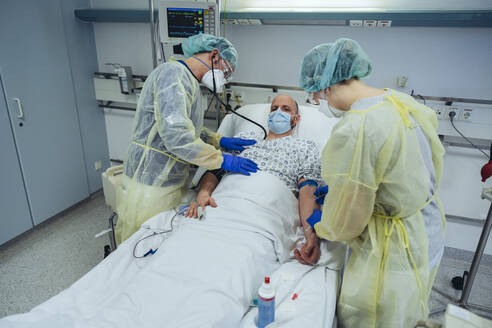 Ärzte, die einen Patienten in der Notaufnahme eines Krankenhauses versorgen, nehmen eine Blutprobe - MFF05307