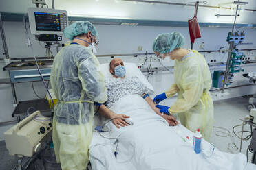 Ärzte, die einen Patienten in der Notaufnahme eines Krankenhauses versorgen, nehmen eine Blutprobe - MFF05308