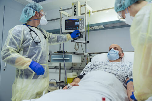 Ärzte, die sich um einen Patienten in der Notaufnahme eines Krankenhauses kümmern - MFF05310