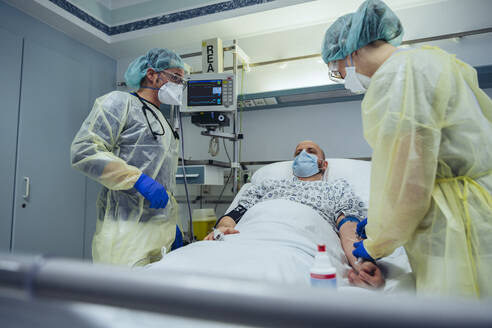 Ärzte, die einen Patienten in der Notaufnahme eines Krankenhauses versorgen, nehmen eine Blutprobe - MFF05311