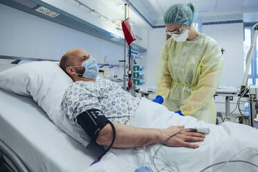 Arzt, der sich um einen Patienten in der Notaufnahme eines Krankenhauses kümmert, nimmt eine Blutprobe - MFF05312