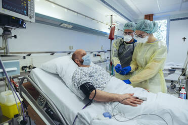 Ärzte, die einen Patienten in der Notaufnahme eines Krankenhauses versorgen, nehmen eine Blutprobe - MFF05314