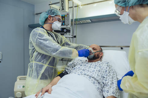 Ärzte versorgen einen Patienten in der Notaufnahme eines Krankenhauses mit Beatmungsgerät - MFF05318