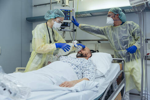 Ärzte mit Beatmungsmaske versorgen einen Patienten in der Notaufnahme eines Krankenhauses - MFF05330