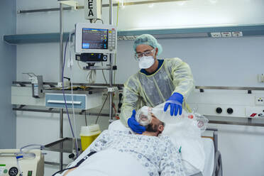Arzt mit Beatmungsmaske bei der Versorgung eines Patienten in der Notaufnahme eines Krankenhauses - MFF05331