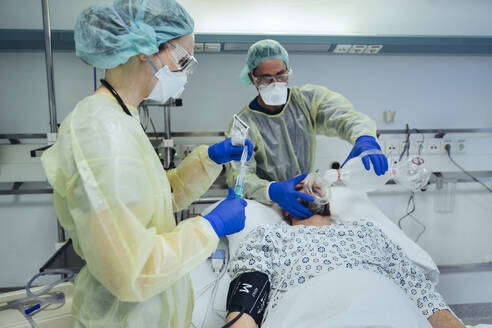 Ärzte, die sich um einen Patienten in der Notaufnahme eines Krankenhauses kümmern - MFF05333