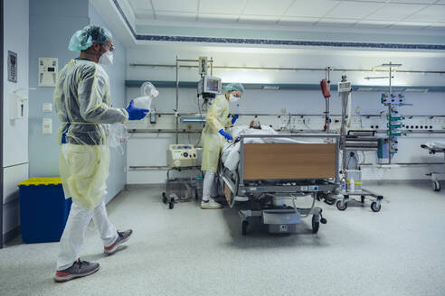 Ärzte, die sich um einen Patienten in der Notaufnahme eines Krankenhauses kümmern, wechseln von einer Sauerstoffmaske zu einer Beatmungsmaske - MFF05337