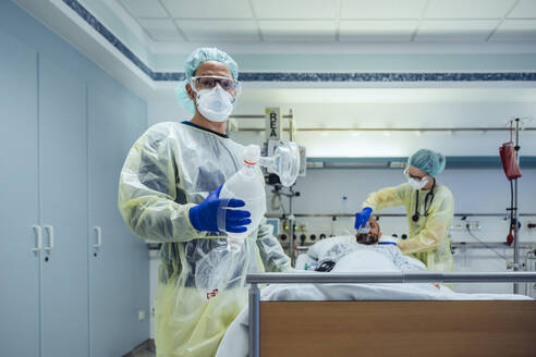 Portrait of doctor in emergency care unit of a hospital holding bag valve mask - MFF05340