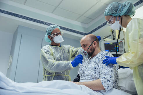 Ärzte, die einen Patienten in der Notaufnahme eines Krankenhauses künstlich beatmen - MFF05342