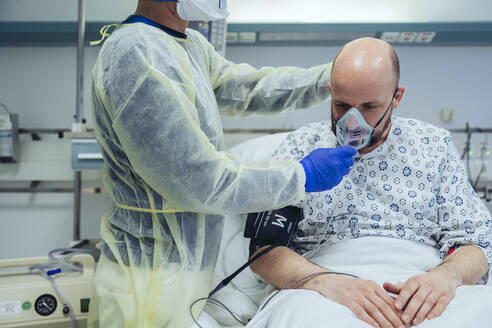 Doctor giving artificial respiration to patient in emergency care unit of a hospital - MFF05345