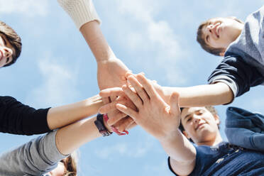 Five friends stacking their hands, seen from below - JCMF00535