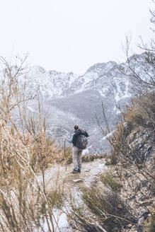 Rückenansicht einer jungen Frau, die auf einem Wanderweg steht und die Aussicht betrachtet, Provinz Leon, Spanien - FVS00001