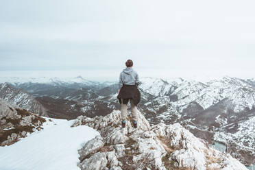 Rückenansicht einer jungen Frau, die auf einem Berggipfel steht und die Aussicht betrachtet, Provinz Leon, Spanien - FVS00005