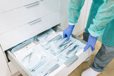 Doctor taking sterile instruments form cabinet - DGOF00623