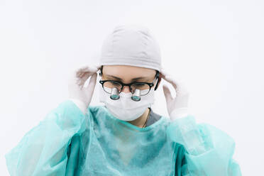 Portrait of dentist with loupe and mask - DGOF00643