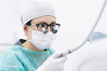 Portrait of dentist with loupe and mask - DGOF00646