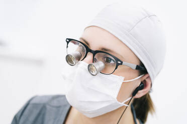 Portrait of dentist with loupe and mask - DGOF00647