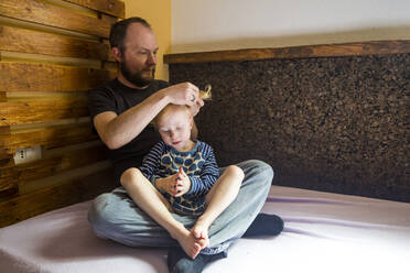 Vater bindet seiner kleinen Tochter die Haare - IHF00311