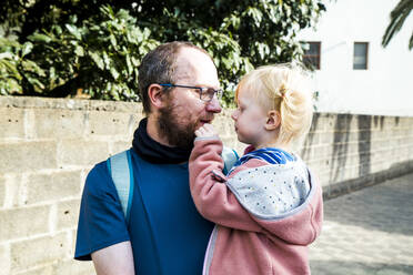 Porträt eines glücklichen Vaters, der seine kleine Tochter trägt - IHF00316