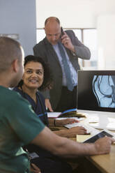 Krankenschwestern besprechen digitales Röntgen am Computer in der Klinik - CAIF24906