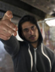 Portrait threatening young man gesturing finger gun - CAIF24980