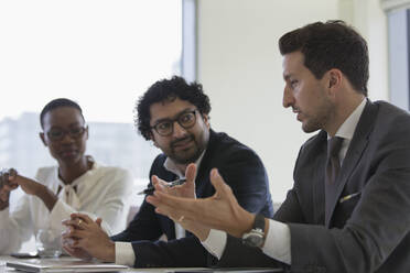 Businessman talking during conference room meeting - CAIF24988