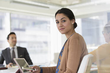 Portrait confident businesswoman with smart phone in conference room meeting - CAIF25005