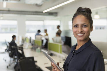 Porträt selbstbewusste lächelnde Geschäftsfrau mit digitalem Tablet im Büro - CAIF25008