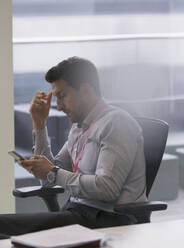 Geschäftsmann benutzt Smartphone im Büro - CAIF25013