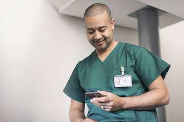 Männlicher Chirurg mit Smartphone - CAIF25024