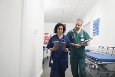 Ärzte mit Krankenblatt bei der Visite im Krankenhauskorridor - CAIF25025