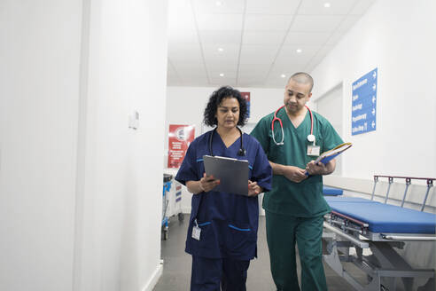 Ärzte mit Krankenblatt bei der Visite im Krankenhauskorridor - CAIF25025