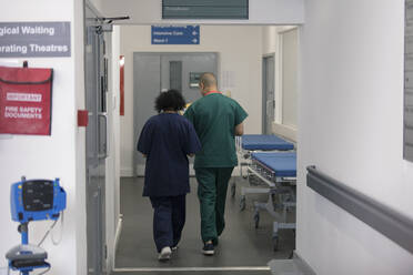 Arzt und Chirurg gehen im Krankenhauskorridor - CAIF25043