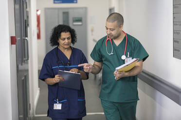 Arzt und Chirurg besprechen Krankenakte, machen Visite im Krankenhauskorridor - CAIF25045