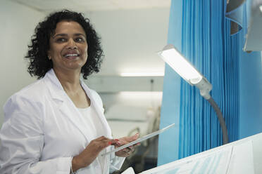 Lächelnde Ärztin mit digitalem Tablet im Krankenhauszimmer - CAIF25055