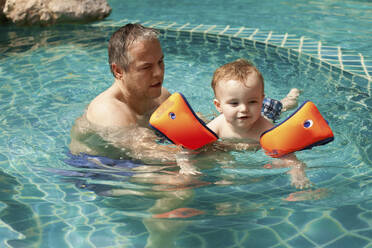Father teaching little son swimming in a pool, Koh Samui, Thailand - AUF00268