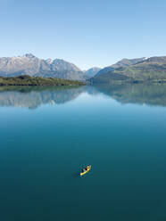 Luftaufnahme von zwei Personen beim Paddeln eines Kanus auf dem Lake Wakitipu, Region Otago, Südinsel, Neuseeland - AAEF07263