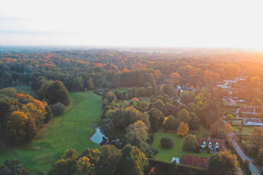 Luftaufnahme einer Golfwiese bei Sonnenaufgang mit bunten Bäumen, Sint-Martens-Latem, Belgien - AAEF07492