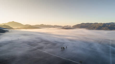 Luftaufnahme eines nebligen Morgens im Jezero-Tal in der Nähe der Stadt Vrgorac in Dalmatien, Kroatien. Dieses Tal ist auch das größte Weinbaugebiet Kroatiens. - AAEF07601