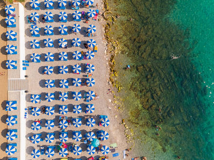 Luftaufnahme von Menschen, die den Sommer am Strand von Medulin, Kroatien, genießen. - AAEF07660