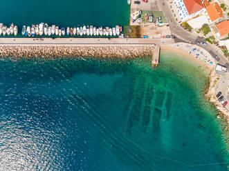 Luftaufnahme über dem Strand in der Nähe des kleinen Jachthafens in Baska, Insel Krk, Kroatien. - AAEF07677