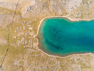 Aerial view above of the Mala Luka beach on the shore of the bay in Baska, Krk island, Croatia. - AAEF07690