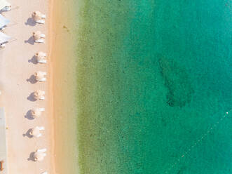 Luftaufnahme von weißen Sonnenschirmen am Strand Vela luka im Sommer in Baska, Insel Krk, Kroatien. - AAEF07696