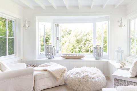 Weiße Vitrine mit Sitzecke und Fenstern zum Garten hin, lizenzfreies Stockfoto