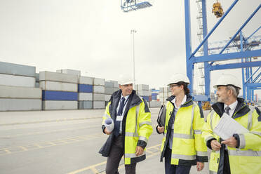 Dockarbeiter und Manager, die auf einer Werft spazieren gehen und sich unterhalten - CAIF25106