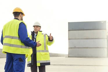 Dockarbeiter und Manager im Gespräch auf einer Werft - CAIF25136