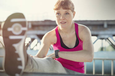 Young female runner stretching leg - CAIF25150