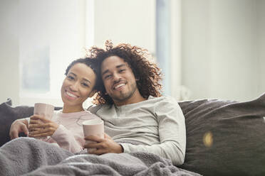 Portrait smiling, affectionate couple relaxing on sofa - CAIF25186